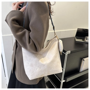 Détail du sac cabas beige avec bandoulière tissée bleue et petit porte-monnaie rond