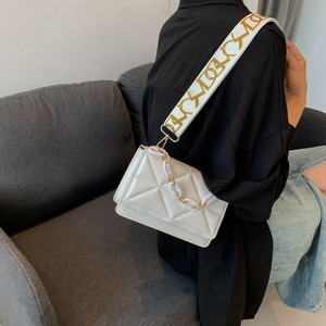 White geometric embossed crossbody bag with wide woven strap and chain detail