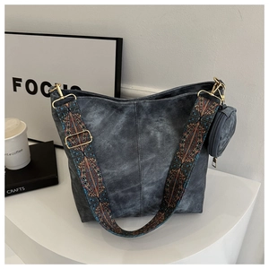 Détail d'un sac cabas en denim gris avec une large bandoulière aux motifs ethniques colorés