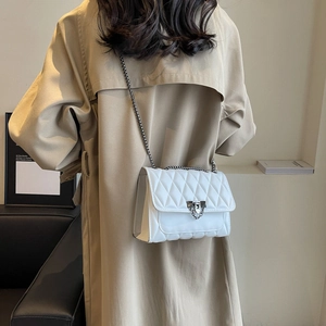 White quilted crossbody bag with diamond stitching and metal chain on model