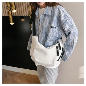 Detail of white nylon crescent crossbody bag featuring an adjustable black wide strap