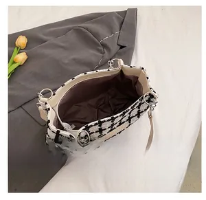 Detail view of the black and white plaid tote bag with brown lining and interior zip pocket