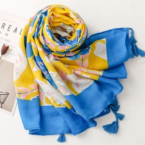 Detail of yellow and blue floral cotton shawl featuring decorative blue tassels on the edges
