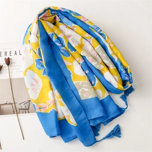 Floral cotton scarf with blue and yellow flower prints and tassels on white background