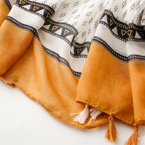 Detail eines Boho-Schals mit gelben geometrischen Mustern und handgefertigten Quasten