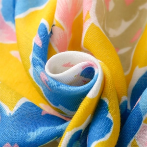 Detailed macro view of yellow and blue floral cotton scarf fabric with soft textures