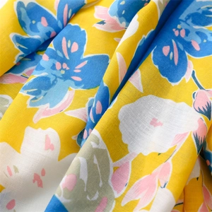 Detail of soft cotton scarf featuring vibrant yellow and blue floral print patterns