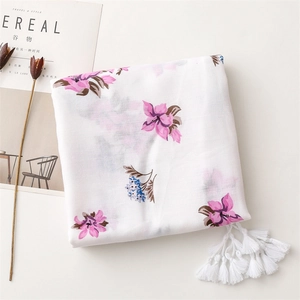 Close-up of ethnic floral print scarf with soft tassels and pink flower patterns