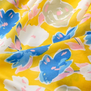 Detailed macro view of yellow and blue floral cotton scarf fabric with soft texture