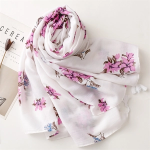 Floral cotton linen scarf with pink blossoms and white tassels on a clean white surface