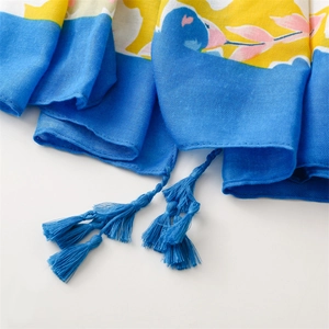Detailed close-up of blue and yellow floral cotton shawl featuring fine handmade tassels