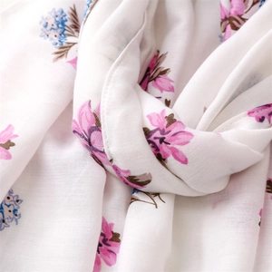 Detail of soft white cotton linen scarf with pink floral prints and fine stitched edges