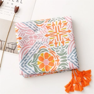 Close-up of geometric floral cotton linen scarf with bright orange tassel details