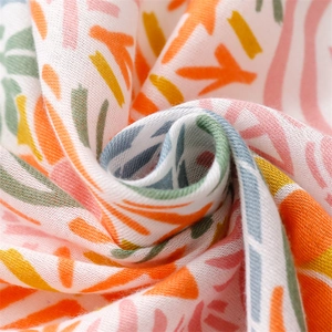 Macro shot of breathable cotton linen scarf with geometric floral print and tassel details