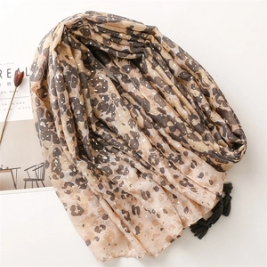 Leopard print scarf with gold foil accents and tassels, elegant lifestyle flat lay