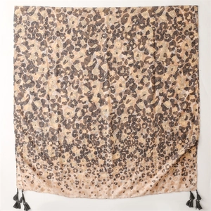 Detailed view of light leopard print scarf featuring elegant black fringe tassels