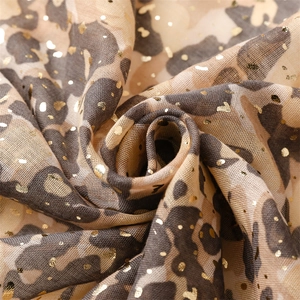 Close-up of leopard print scarf featuring shimmering gold foil accents and lightweight fabric