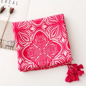 Detailed macro view of pink floral pattern and fringe tassels on a cotton linen scarf