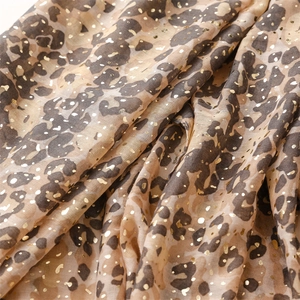Detail of soft leopard print scarf featuring golden foil dots and delicate fringe texture