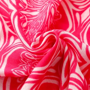 Macro detail of red and white paisley pattern on cotton-linen scarf with weave texture