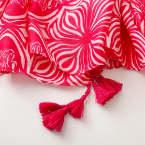 Detail of pink cotton linen scarf with geometric floral print and handcrafted tassels
