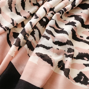 Detailed macro view of the soft cotton-linen scarf with leopard print and fringe texture