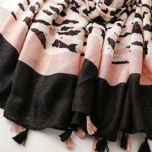 Close-up of leopard print linen scarf showing soft fabric texture and pink tassel fringe