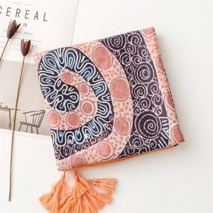 Detail of exotic boho scarf with orange tassels and intricate geometric patterns