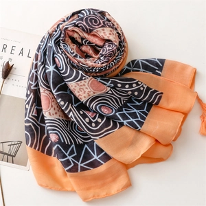 Ethnic boho style cotton linen scarf with geometric prints and orange tassels flat lay