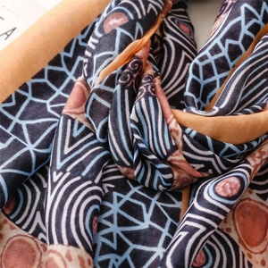 Macro detail of geometric folk pattern on lightweight cotton linen scarf with soft fringe