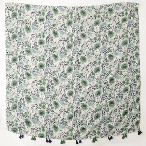 Floral green beach shawl with fringe edges on white background, lightweight beach wrap
