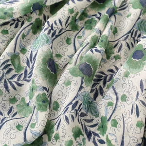 Close-up of green floral cotton-linen fabric texture with artistic hand-painted patterns