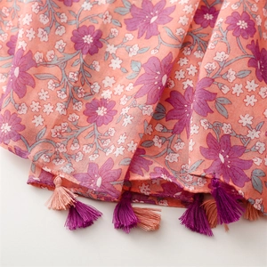 Detail shot of orange floral cotton linen shawl with purple fringe tassels