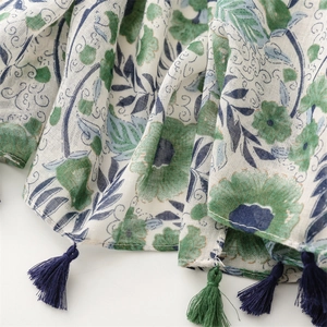 Detailed view of green floral cotton-linen scarf with elegant handmade tassel fringe