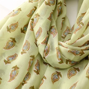 Detailed texture of light green beach shawl with ethnic paisley leaf patterns