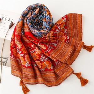 Detail of ethnic style red floral shawl with blue patterns and bohemian tassels