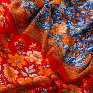 Detail of bohemian red and blue ethnic pattern fabric with floral prints and soft texture