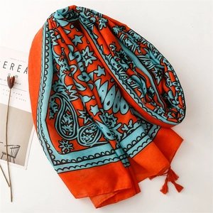 Ethnic style paisley shawl in orange and turquoise with tassels for travel photography