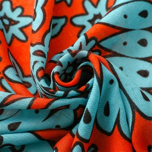 Detailed close-up of vibrant orange and blue ethnic floral print cotton-linen shawl fabric
