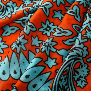 Macro shot of ethnic paisley floral print on orange cotton-linen blend fabric