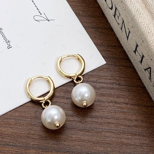 French vintage style earrings featuring round white pearls with polished gold hoops