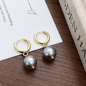 Detailed close-up of vintage gold hoop earrings with elegant dark grey pearl pendants