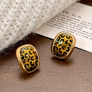 Boucles d'oreilles ovales léopard vintage avec bordure dorée sur fond en tricot