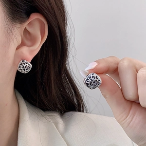 Irregular geometric earrings with leopard print and gold plating shown on model and hand