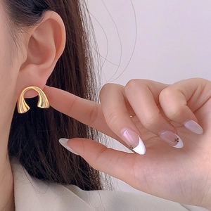 Minimalist U-shaped gold-plated stud earrings shown on a model for a luxury look