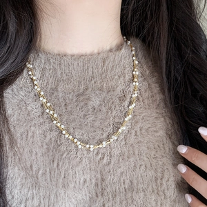Three-layer pearl beaded necklace with gold plated chain on model in soft sweater