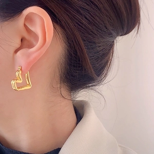 Luxurious gold heart-shaped hoop earring shown on a model for a stylish look