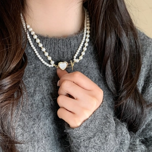 Double-layer pearl necklace with heart shell pendant and gold OT clasp on model