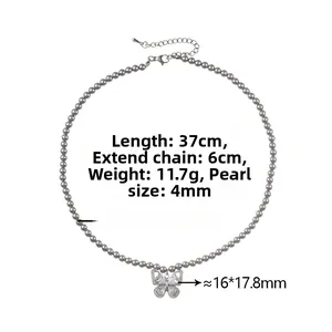 Vue détaillée d'un collier de perles grises avec un pendentif nœud serti de diamants