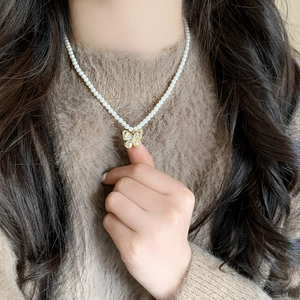 Collier en perles avec pendentif nœud de style français porté avec élégance rétro